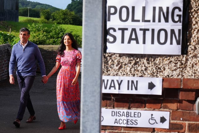 Rishi Sunak and his wife Akshata Murty walking hand-in-hand to a polling station