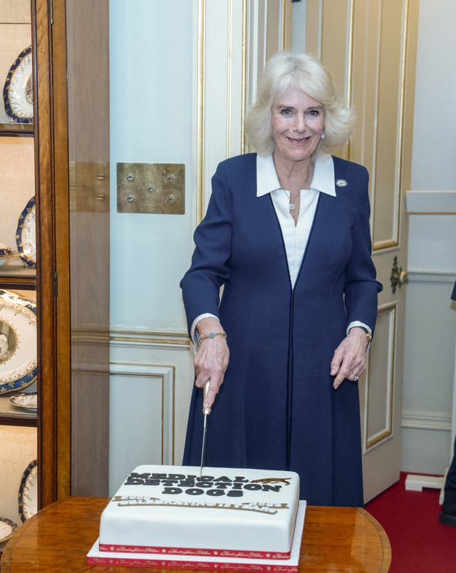 The Queen cuts a cake as she hosts a reception to mark the 15th anniversary of the Medical Detection Dogs charity