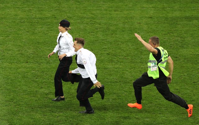 Members of the public are chased by security staff during the FIFA World Cup Final at the Luzhniki Stadium, Moscow.