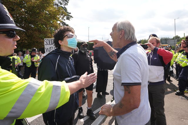 A counter-protester speaks to a Stand Up To Racism protester at a rally outside the Four Points By Sheraton hotel in Horley, Surrey