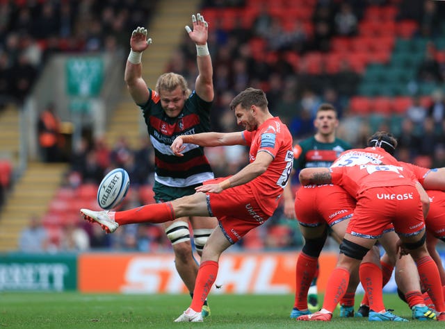 Leicester's David Denton attempts to block a kick from Sale's Will Cliff