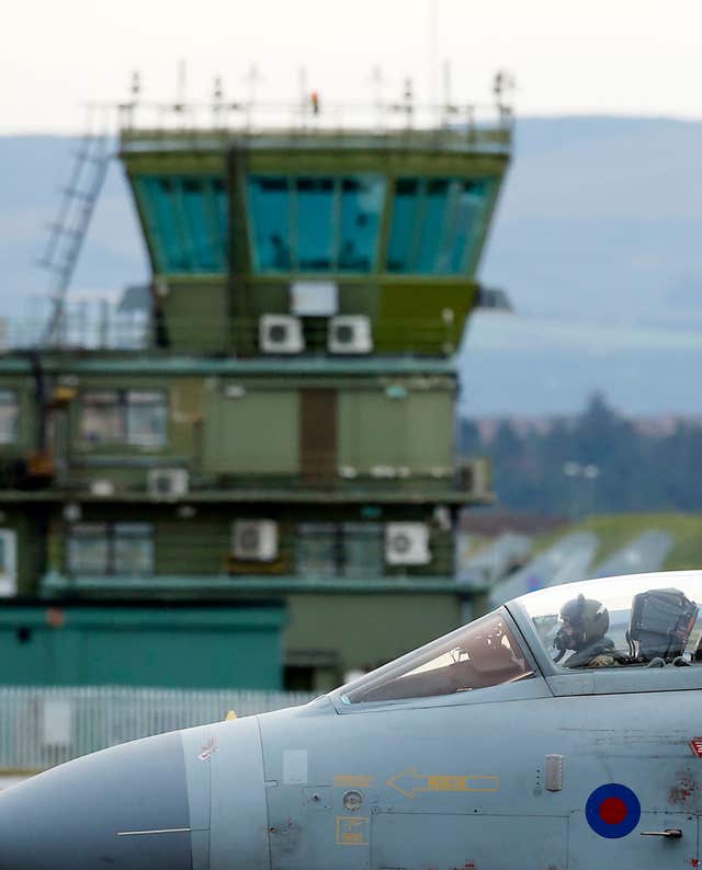 A view of the cockpit of an RAF jet, with an air traffic control tower in the background