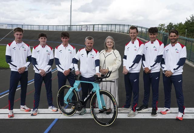 Frances Connolly, centre, alongside men wearing tracksuits including one standing next to a bike