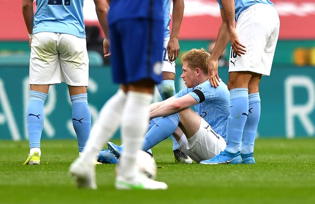 Kevin De Bruyne sits on the pitch injured