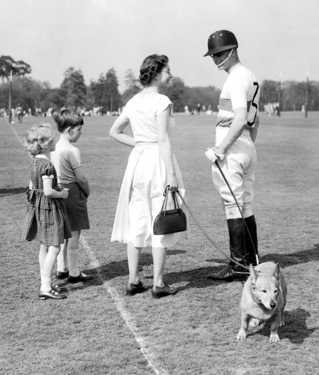 The Queen holds one of the Royal corgis in 1956 (PA)