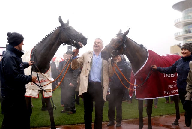 Owner Michael O’Leary (centre) celebrates in the parade ring after winning the Glenfarclas Chase with Delta Work (left), alongside runner-up Tiger Roll