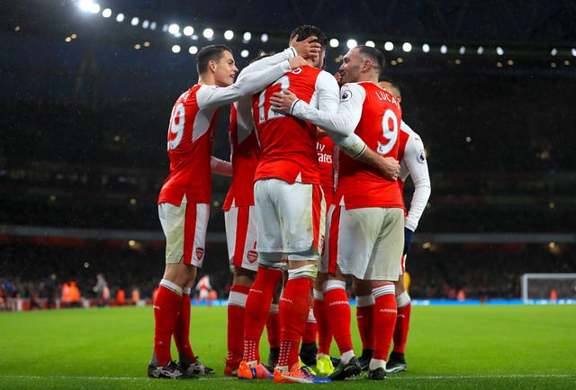 Grioud is mobbed by his Arsenal team-mates following his first-half goal at the Emirates