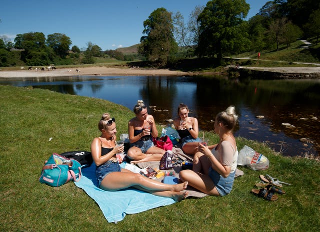 (Left to right) Kate Wormald, Lizzie Walker, Fiona Oddy and Millie Arnison enjoy the hot weather at Bolton Abbey in North Yorkshire