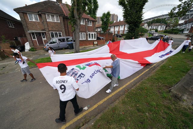 Local residents carry an official giant England Nationwide respect campaign flag from Neeld Crescent in Brent, where Raheem Sterling grew up, to Wembley Stadium, ahead of the Euro 2020 final