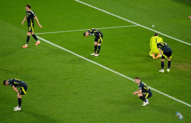 Scotland’s players show their dejection after conceding a last-minute goal 