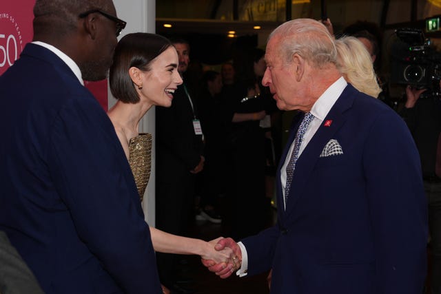 Lily Collins shakes hands with the King 