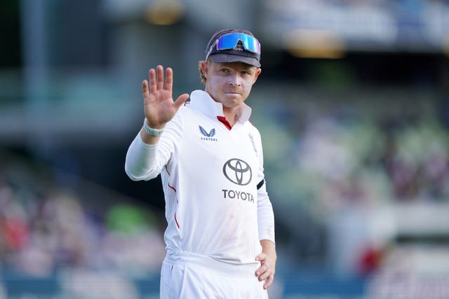 Ollie Pope waves while fielding for England.