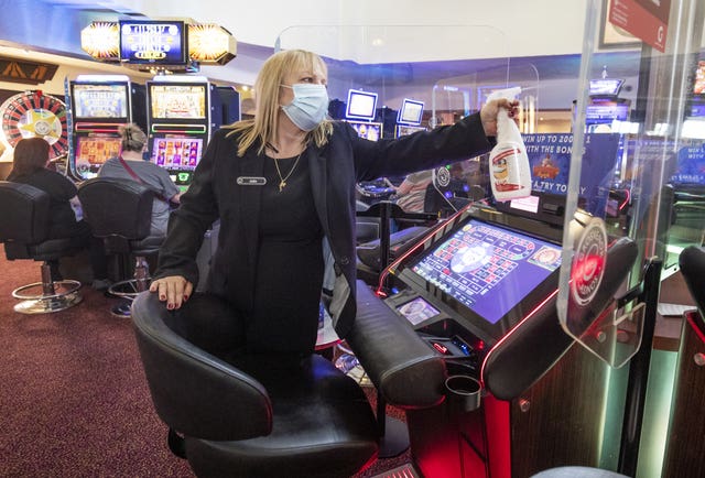 Staff member cleans gaming machine screens