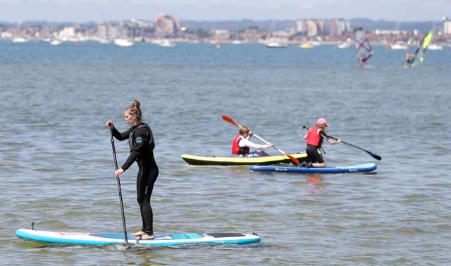 Paddle boarders enjoy the warm weather in Poole Harbour in Dorset 