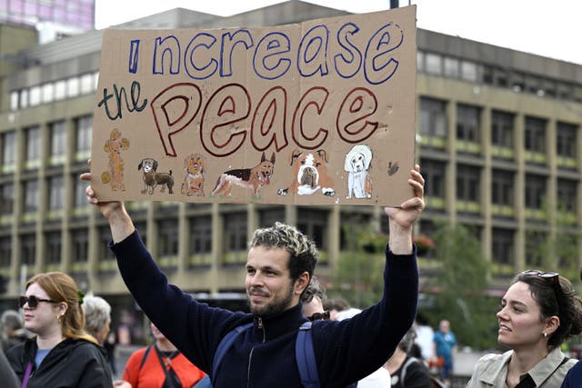 A man holding a sign saying increase the peace