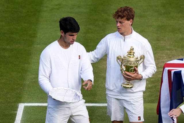 Jannik Sinner with the men's singles trophy alongside Carlos Alcaraz with his runners up trophy