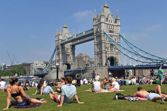 People sitting in the sun at Potters Field Park, London (John Stillwell/PA)