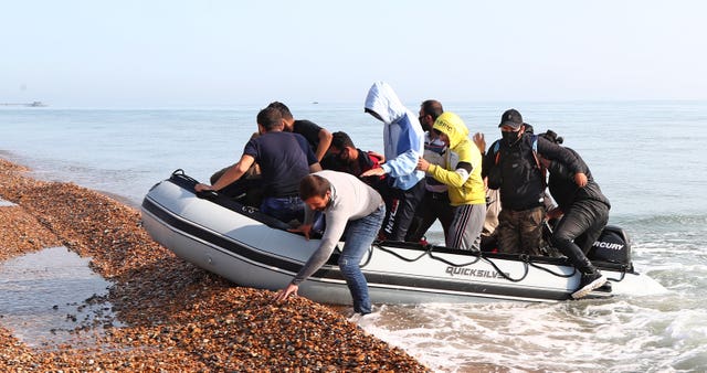 A group of people thought to be migrants arrive in an inflatable boat at Kingsdown beach, near Dover