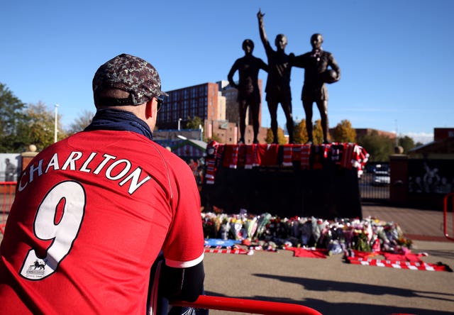 Tributes are laid in memory of Sir Bobby Charlton by The United Trinity statue at Old Trafford