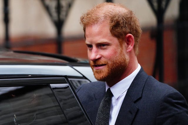 Prince Harry next to a black car