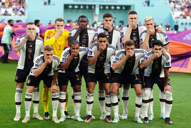 Germany players cover their mouths as they pose for a team group photo after FIFA threatened them with sporting sanctions if they wore the OneLove armband