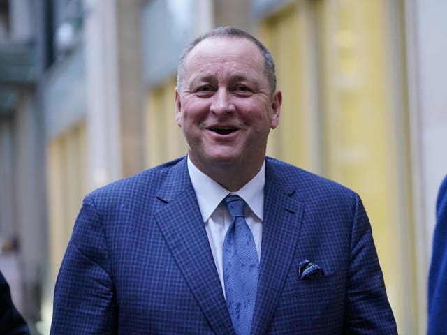 Mike Ashley smiling, dressed in blue suit