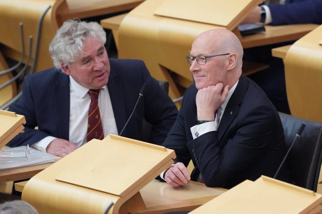 Finance Committee convener Kenneth Gibson with First Minister John Swinney sitting in Scottish Parliament seats