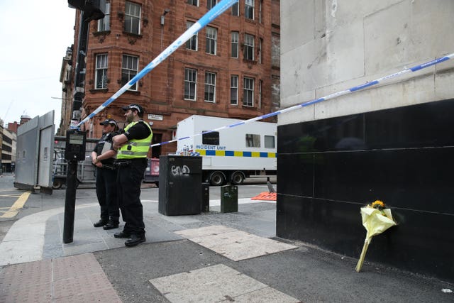 Police, alongside a floral tribute,