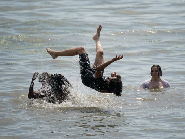 People play in the water at Southend-on-Sea on the Thames Estuary in Essex 