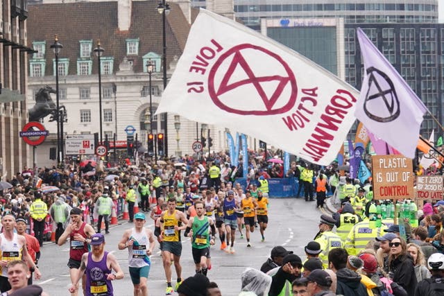 Runners pass climate protesters