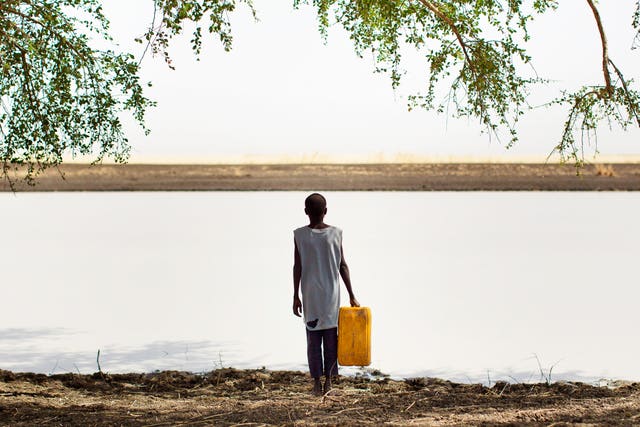 A boy gathers water beside a watering hole,in a remote area along the Sobat River in the Greater Upper Nile region of northeastern South Sudan (Julien Behal/AP)