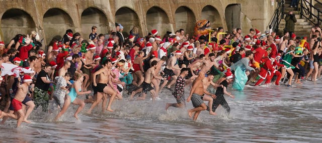 Swimmers take part in the Folkestone Lions’ Boxing Day Dip at Sunny Sands Beach in Folkestone, Kent 