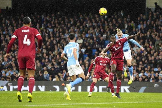 Erling Haaland heads a goal for Manchester City against Liverpool