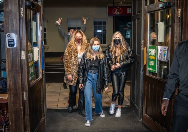 Left to right Rebecca Mitchell, Rosie Delaney and Isobel Logan enter the Showtime Bar just after midnight in Huddersfield, West Yorkshire (Danny Lawson/PA)