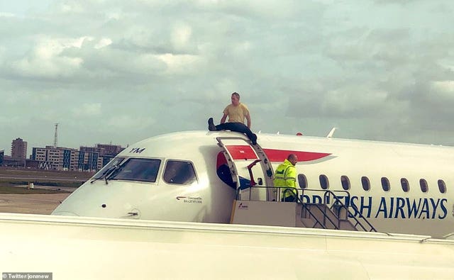Extinction Rebellion activist James Brown on top of a plane on October 10 2019 during a protest