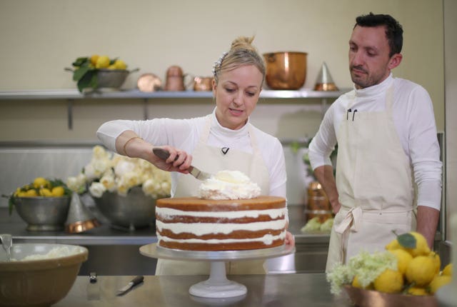 Claire Ptak, owner of Violet Bakery in Hackney, and head baker Izaak Adams put finishing touches to the cake for the wedding of Prince Harry and Meghan Markle in the kitchens at Buckingham Palace (Hannah McKay/PA)
