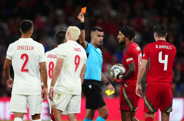 Referee Rohit Saggi, centre, shows a red card to Turkey’s Baris Alper Yilmaz, centre left