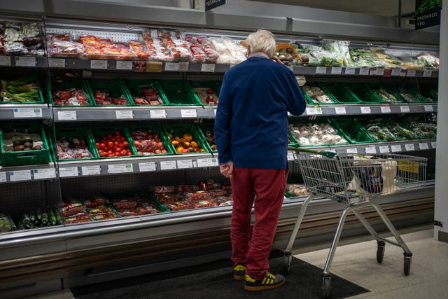 A shopper looks at salad vegetables in a branch of Waitrose in south London
