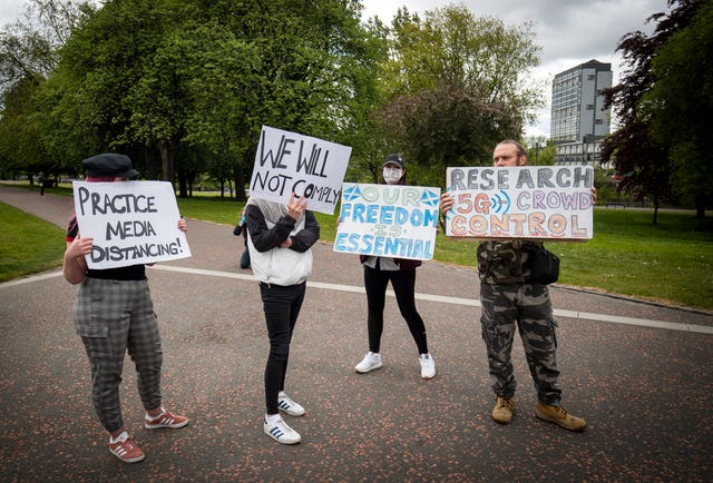 Members of the public hold signs at the Glasgow protest 