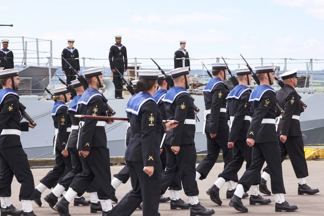 Navy sailors wander by HMS Spey during its commissioning