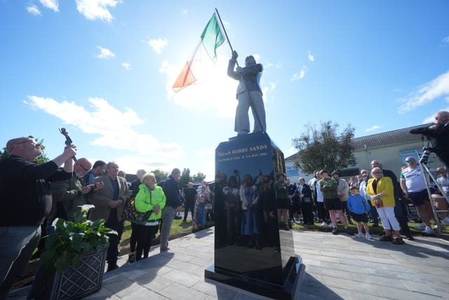 Members of the public attend the unveiling of the first Bobby Sands statue on Gardenmore Road, Belfast