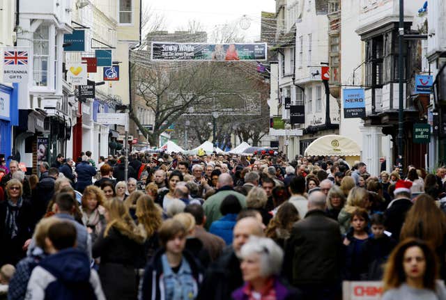 Crowds of people in a street of shops 