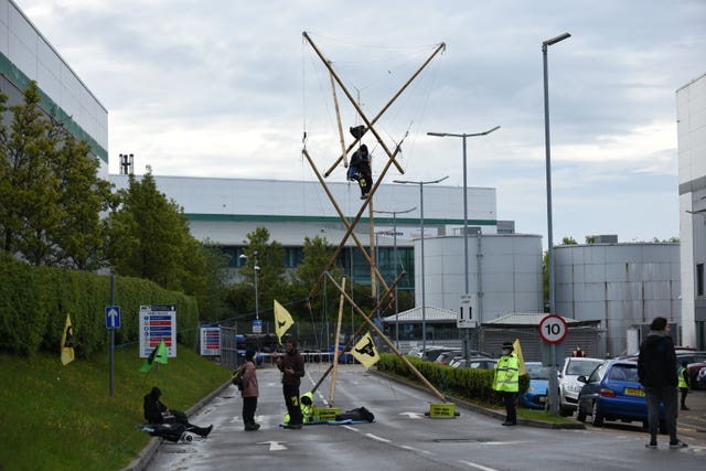 Protesters suspended from a bamboo structure outside a McDonalds distribution site in Basingstoke, Hampshire