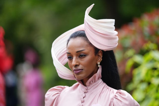 A woman wears a pink hat
