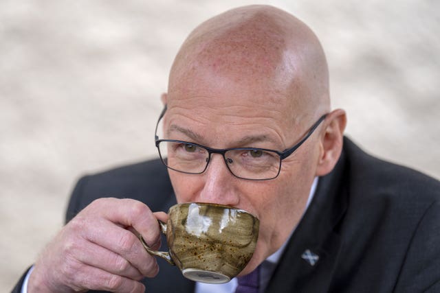 Scottish National Party Leader John Swinney sips coffee during a visit to The Dower House Cafe in Edinburgh