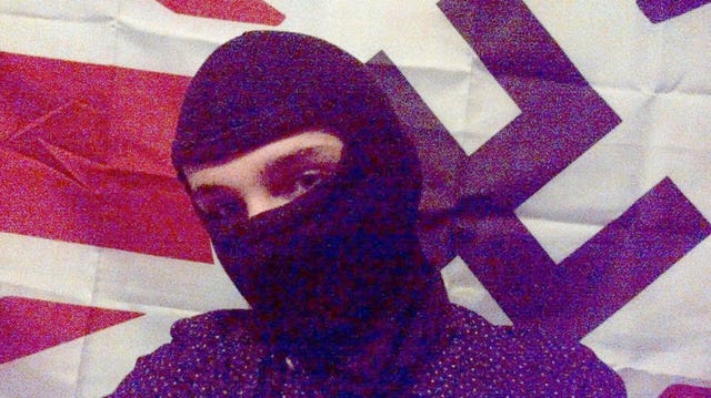 Mark Jones, in a black balaclava pictured in front of a Union Flag bearing the Nazi Swastika. 