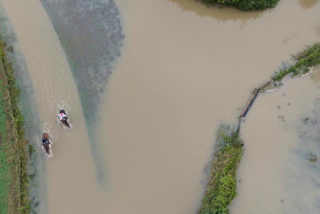 Horse riders make their way through flood water in Walton in Warwickshire.