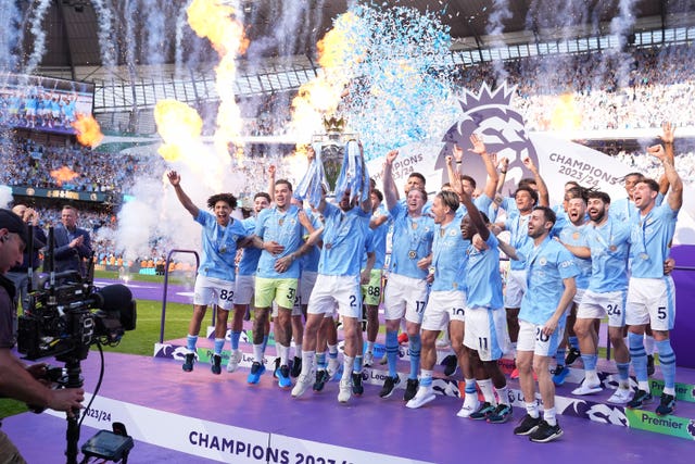 Manchester City captain Kyle Walker lifts the Premier League trophy after Manchester City secured a fourth straight title