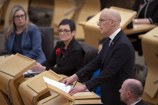 John Swinney standing while speaking in Holyrood