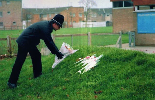 A policeman leaving flowers at Welland County Primary School in Peterborough, the school of murdered Rikki